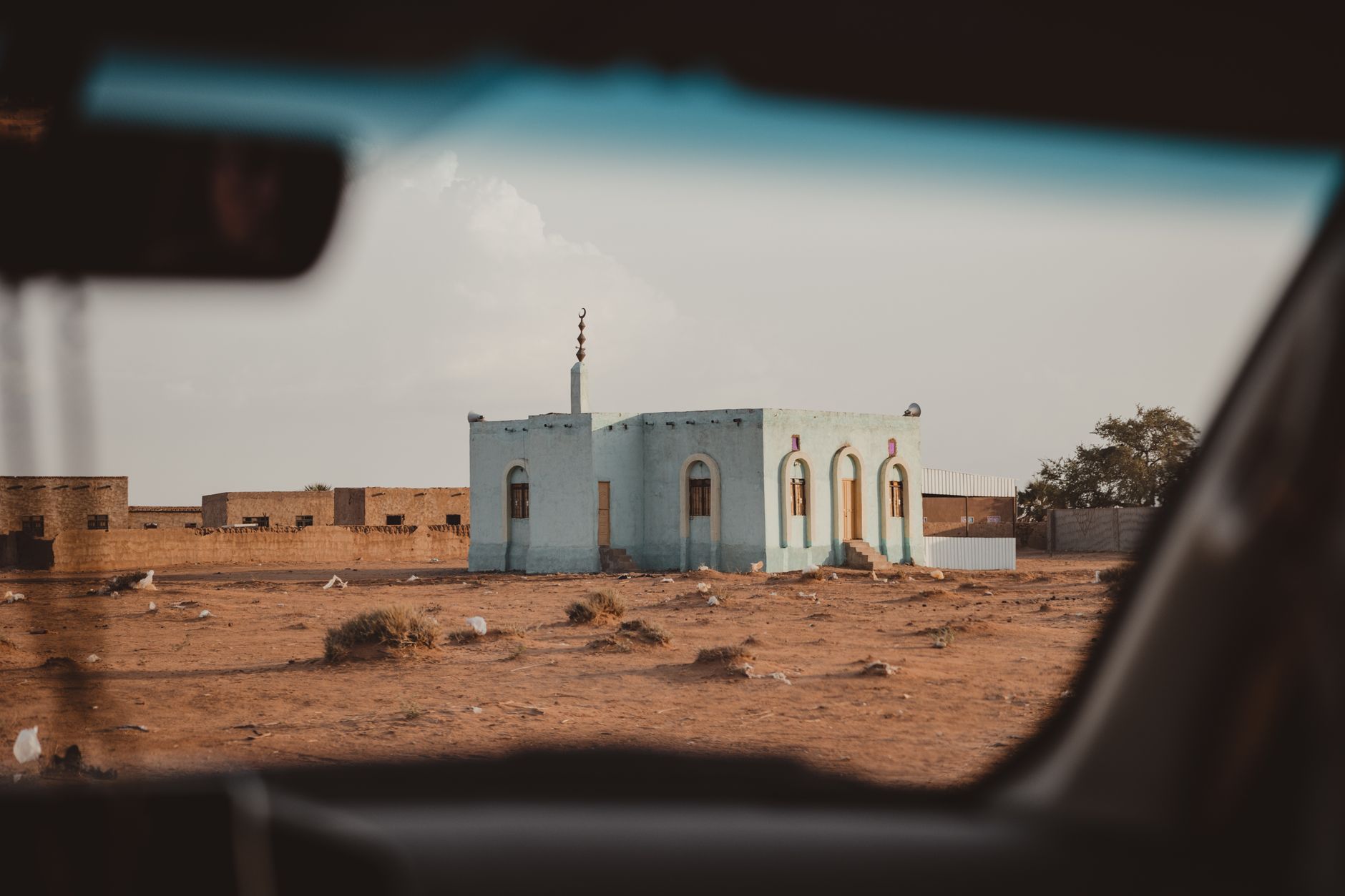 Isolated roadside whitewashed mosque along the arid desert highway corridor in northern Sudan
