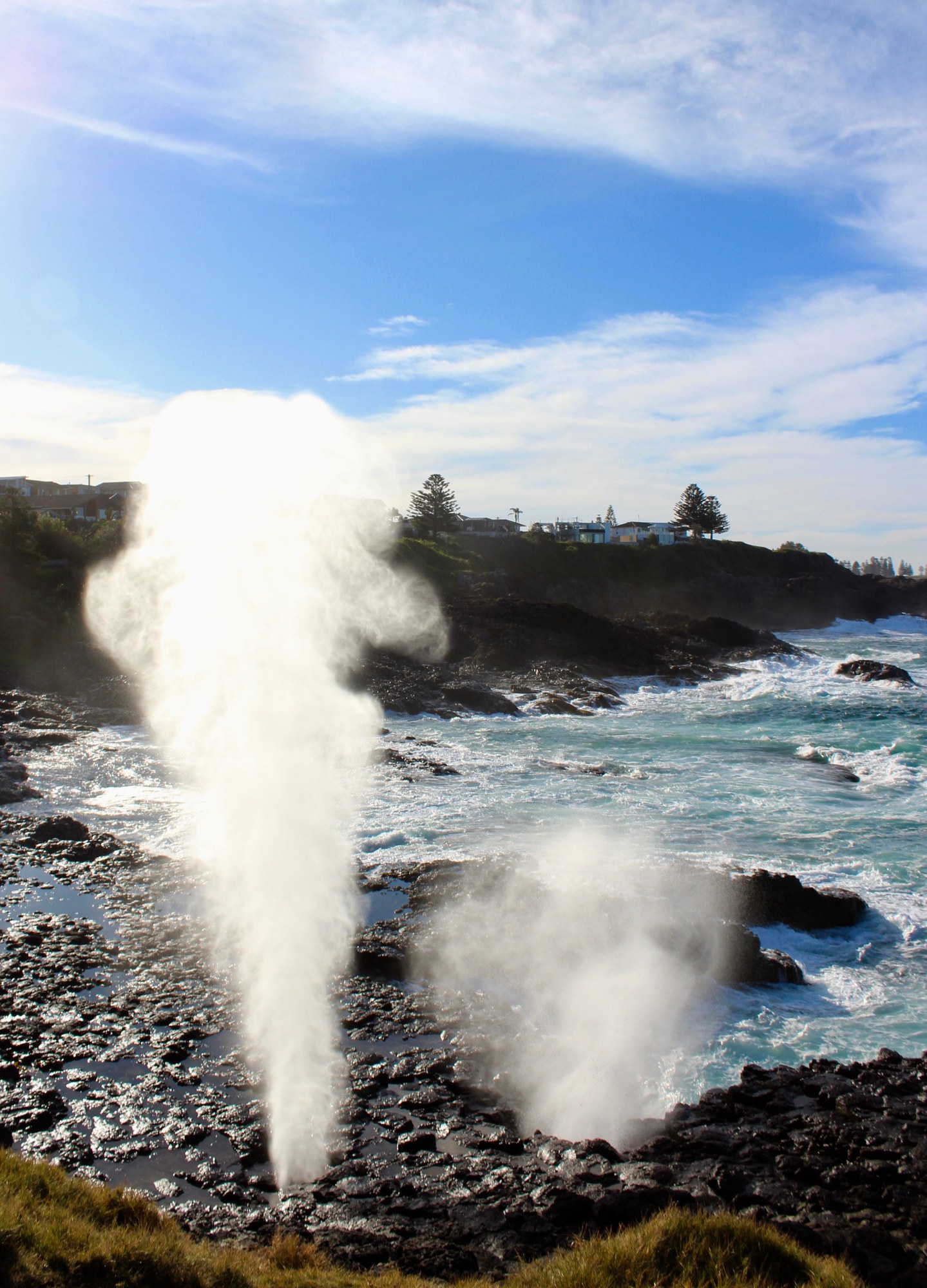 Sea spray erupting from limestone coastal rock shelf along the ocean