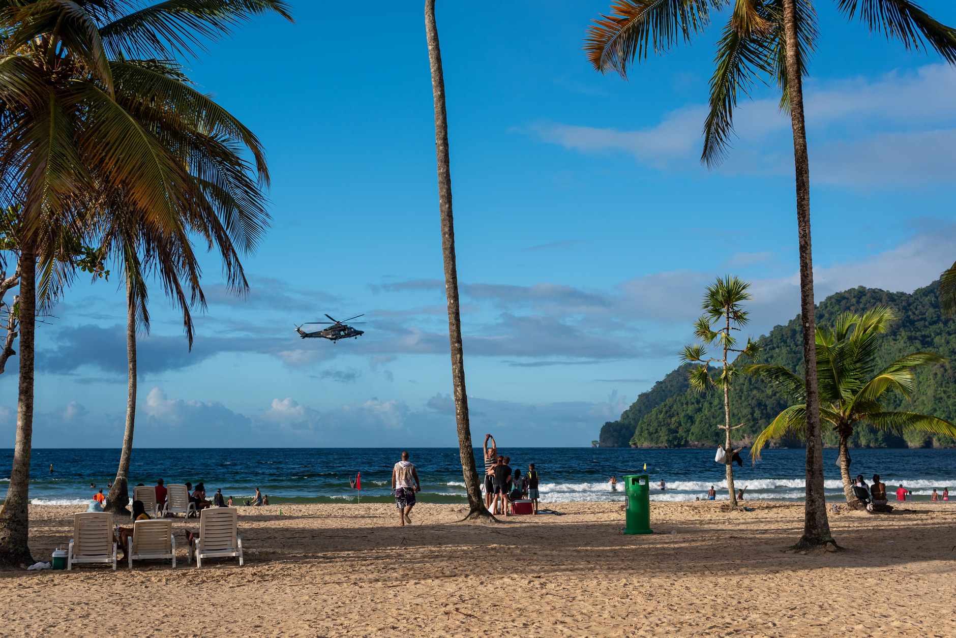 Panoramic view of the golden sandy arc and tropical forested bluffs at Maracas Bay