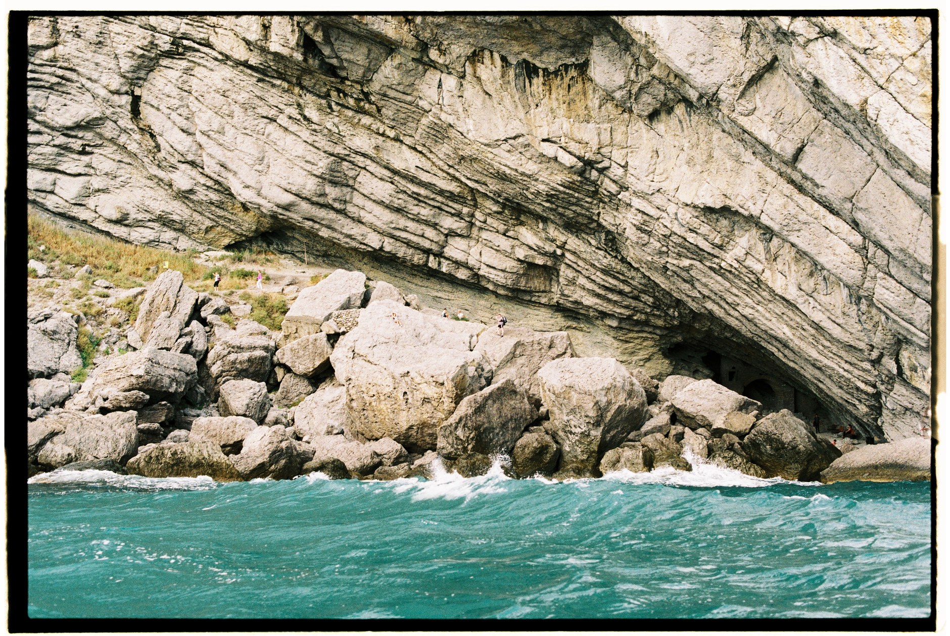 Dramatic limestone bluffs and turquoise Atlantic waves framing Mudjin Harbour on Middle Caicos