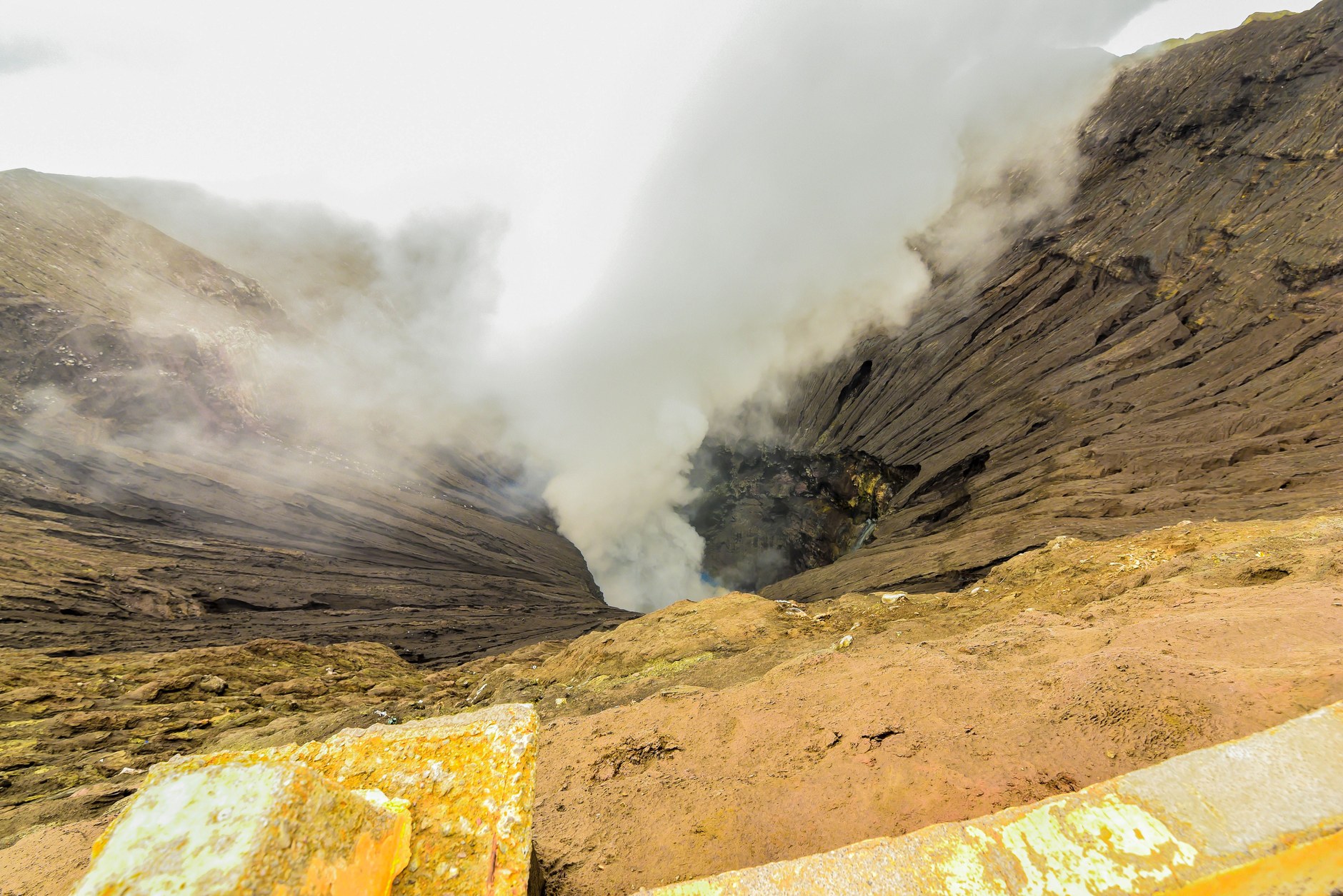 View into the smoking active crater of Mount Yasur with volcanic steam rising from the abyss