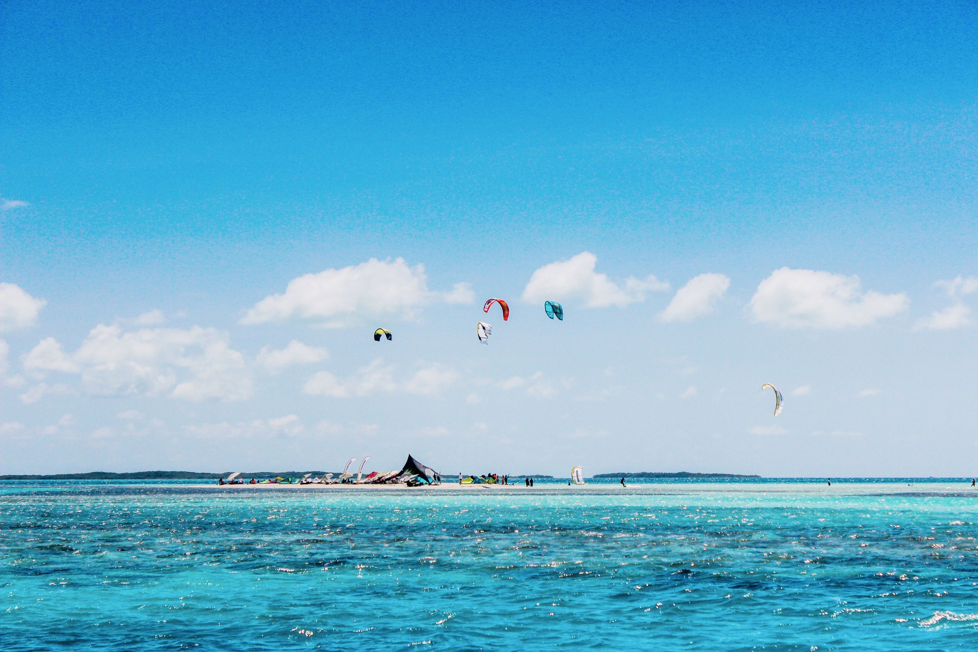 Kitesurfer gliding over clear turquoise waters in Los Roques Archipelago, Venezuela