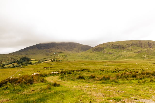 Breathtaking view of the lush Kerry mountains under cloudy skies in Ireland.