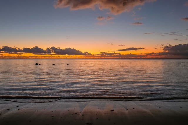 A breathtaking sunset view over the serene waters and sandy beach of Mauritius' Moka District.