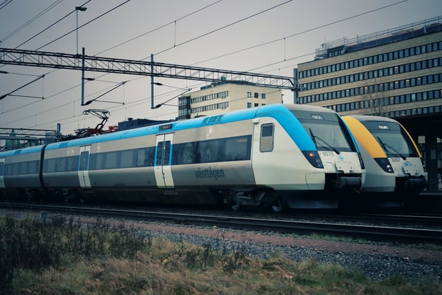 Two modern passenger trains at Jönköping railway station in Sweden, showcasing urban transportation.