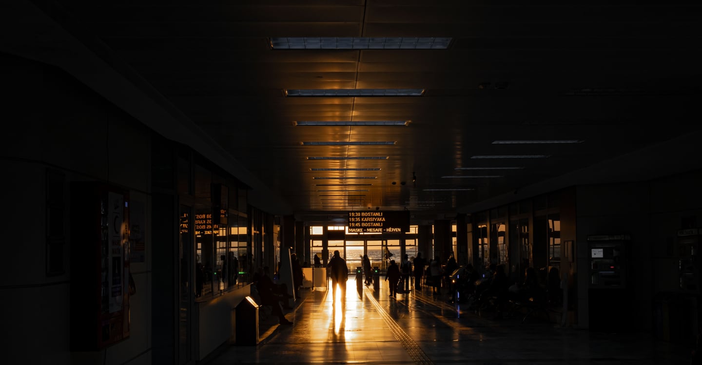 Travelers in airport terminal walkway during sunset