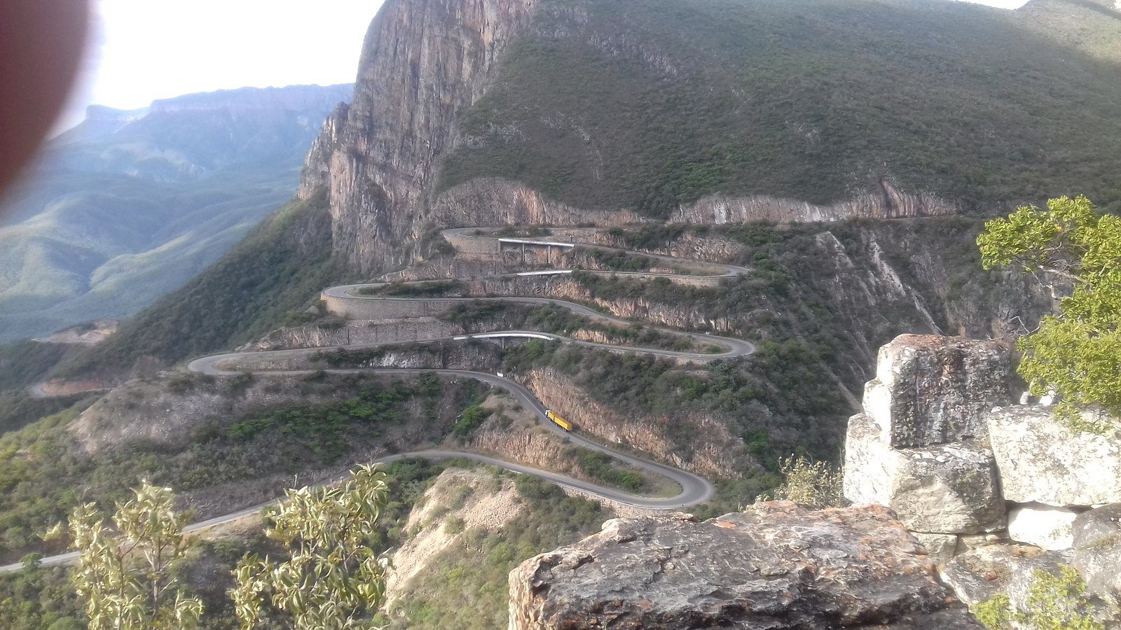 Dramatic winding hairpin curves of the Serra da Leba mountain pass road illuminated against green mountain slopes in Angola