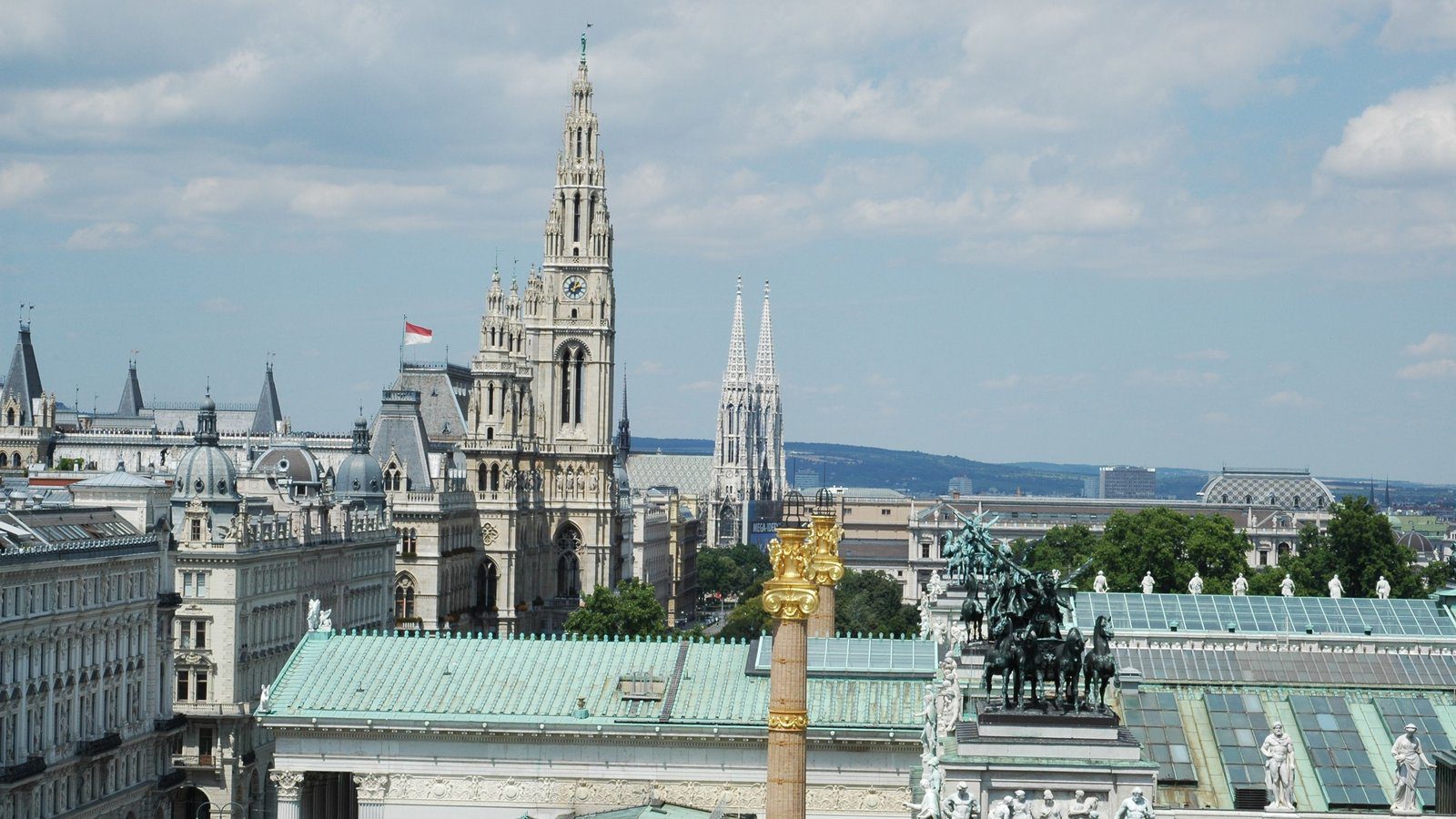 Aerial view of Vienna showcasing the town hall, Votivkirche, and architectural landmarks.
