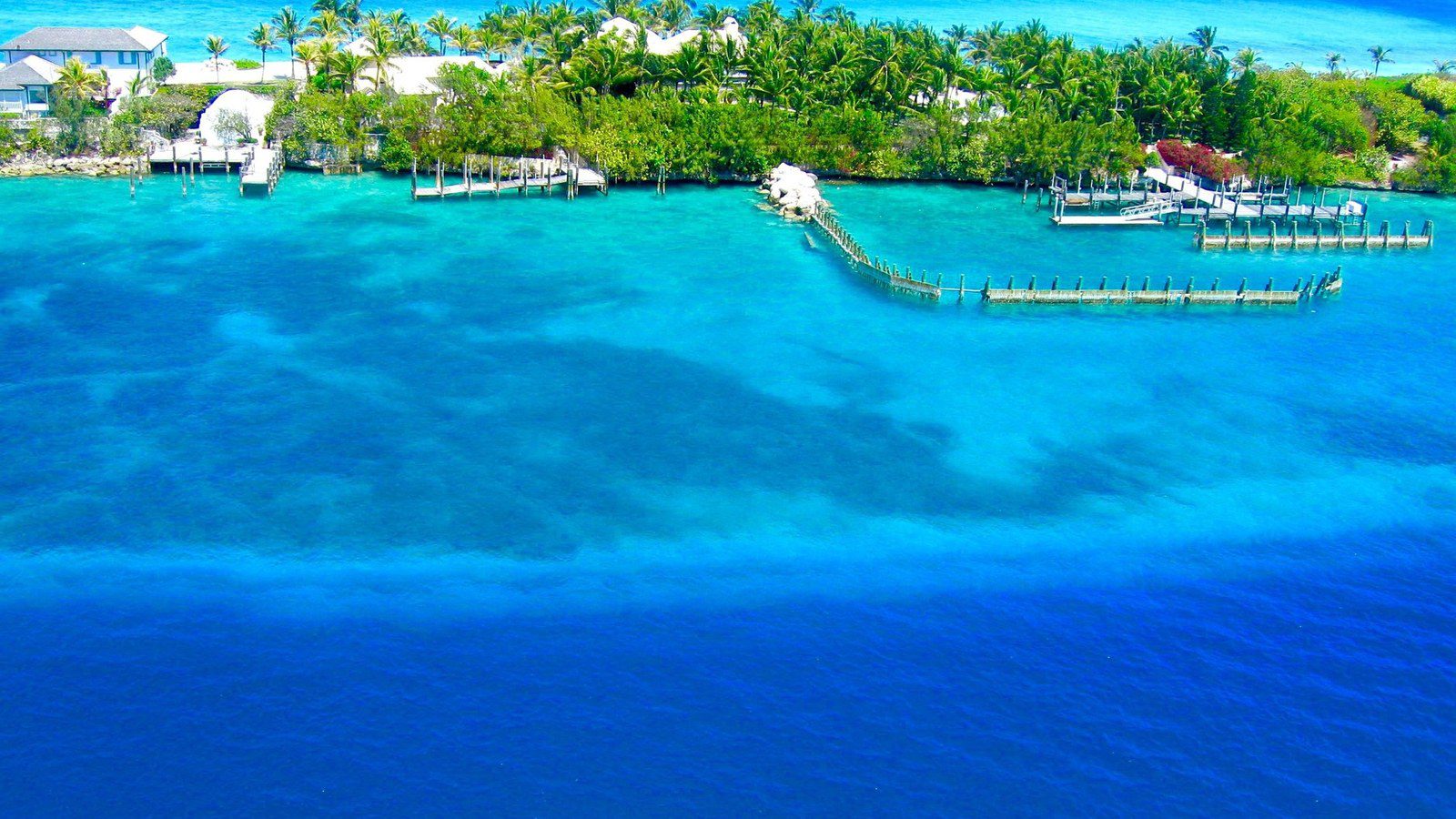 Aerial panorama of tropical island coastline and shallow turquoise ocean waters in the Bahamas