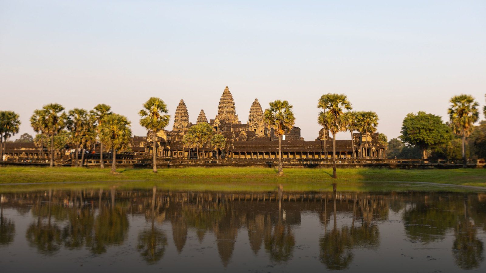 Silhouette of Angkor Wat's central stone lotus towers reflected in the northern lily pond at sunrise