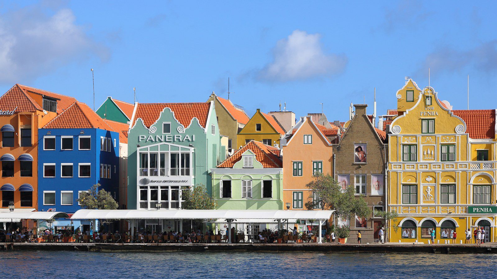 Vibrant pastel-colored Dutch colonial merchant facades along the Handelskade waterfront in Willemstad, Curaçao