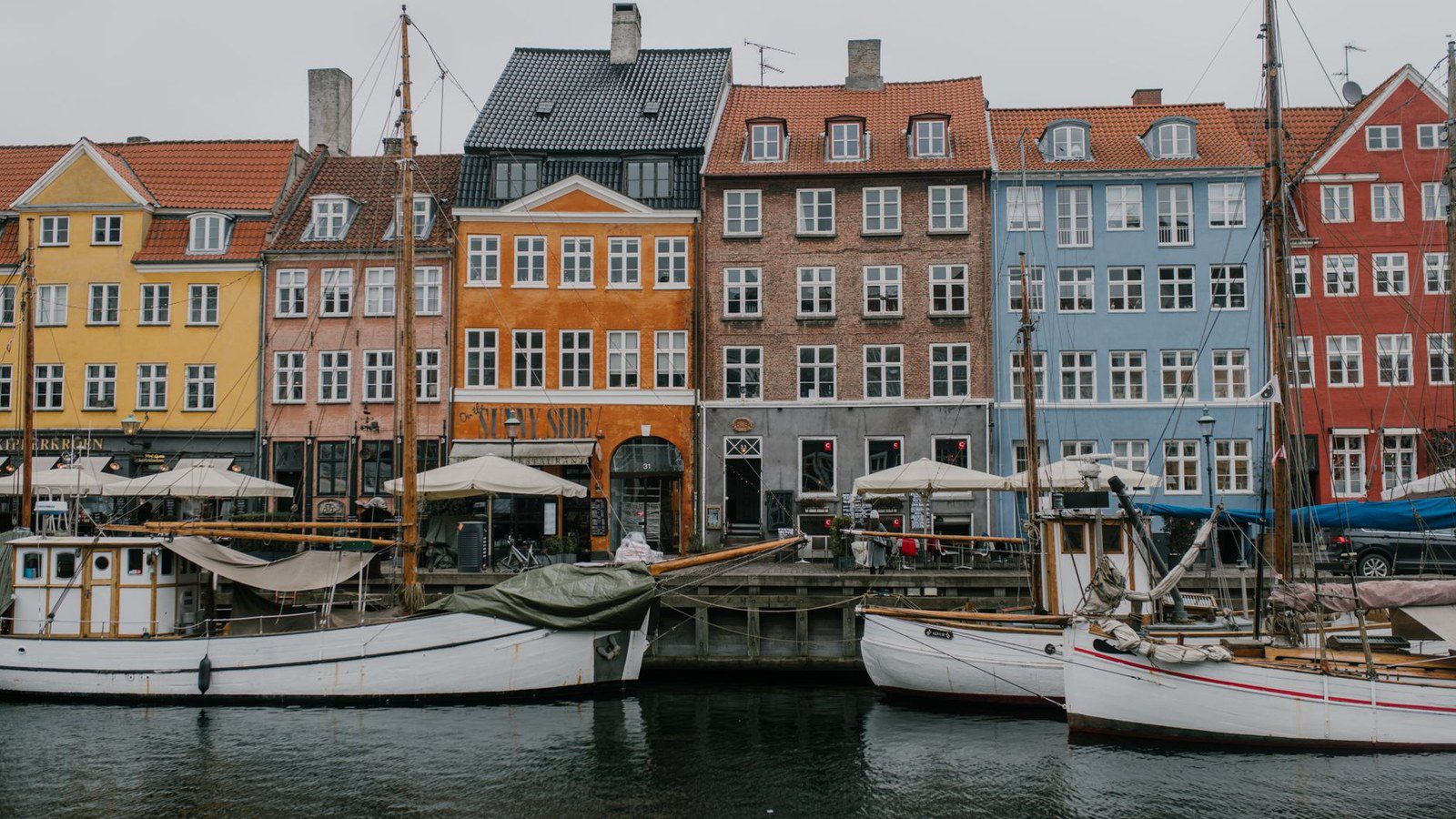 Vibrant view of Nyhavn canal with colorful buildings and boats in Copenhagen, Denmark.