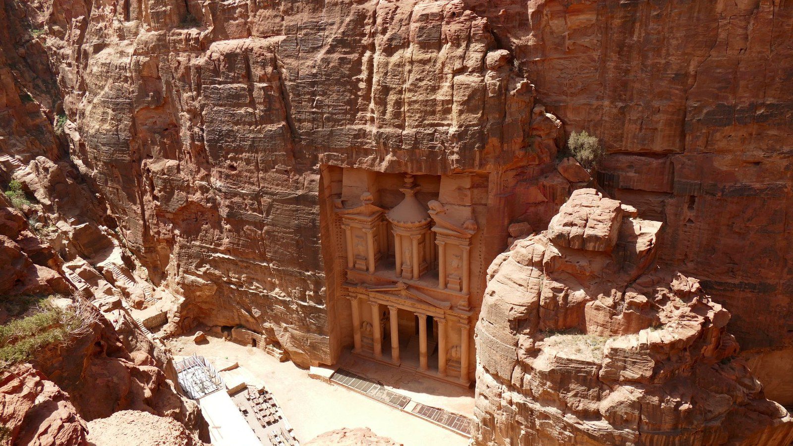 Aerial view of Petra's iconic Al-Khazneh Treasury carved into red sandstone cliffs, Jordan.