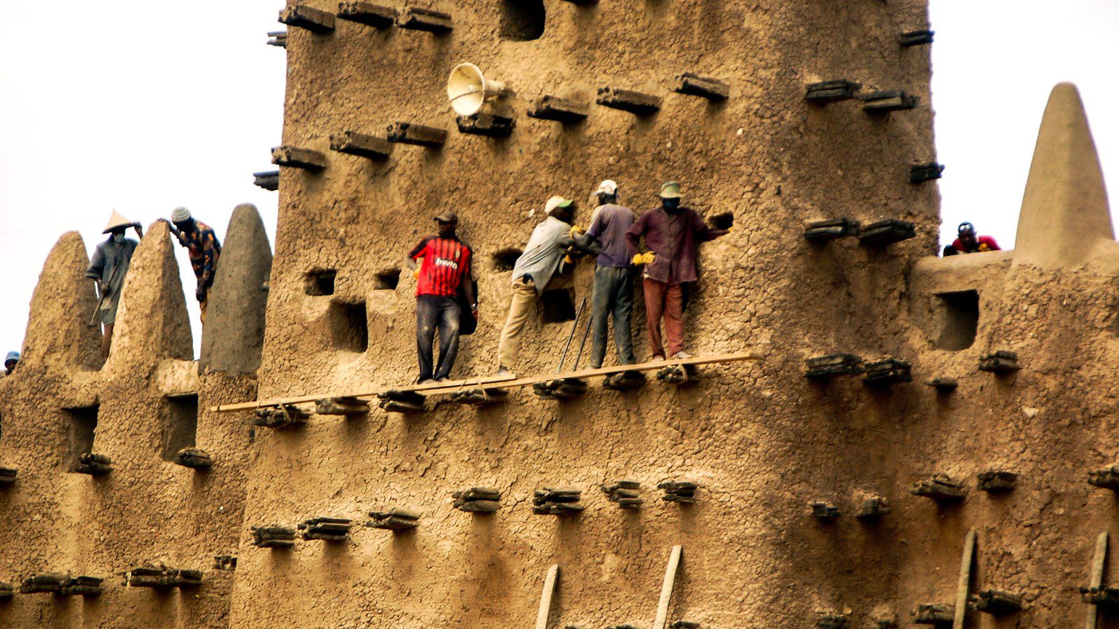 Historic monumental adobe mudbrick facade of the Great Mosque of Djenné with protruding palm wood beams in Mali