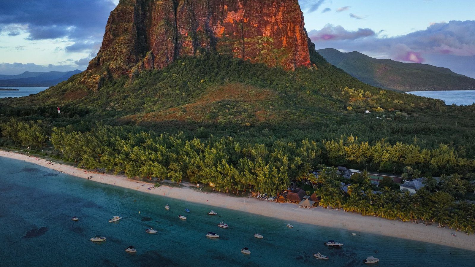 Steep basalt monolith of Le Morne Brabant rising above a turquoise coastal coral lagoon in southwest Mauritius