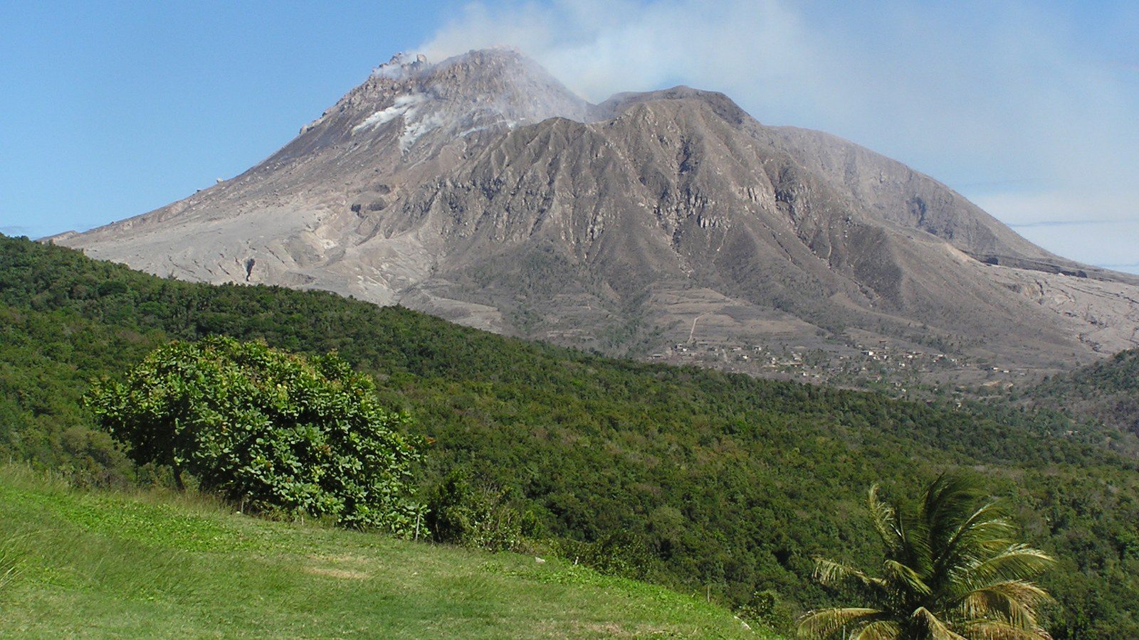 Dramatic aerial view of the volcanic dome and ash-covered ridges of Soufrière Hills volcano in southern Montserrat