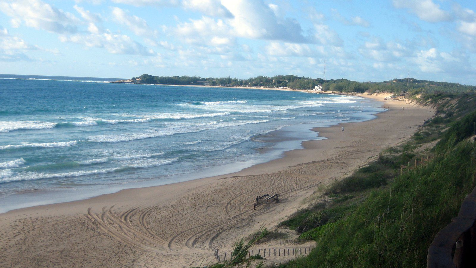 Scenic travel view of turquoise waters and coastal dunes at Praia do Tofo, Mozambique