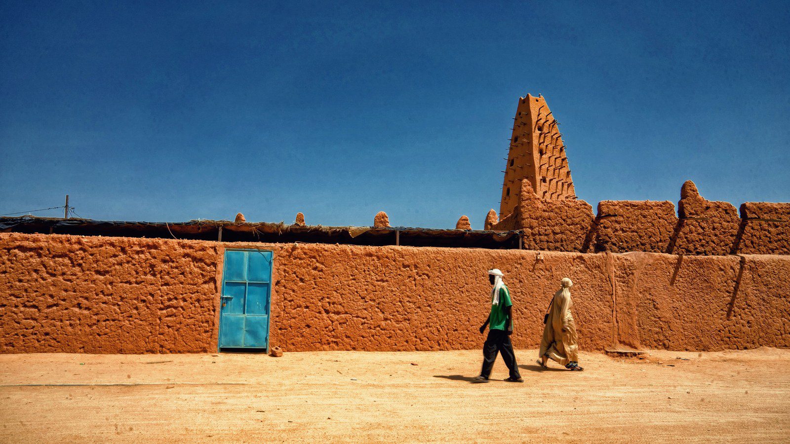 Iconic tapering earthen minaret of the Grand Mosque of Agadez with protruding wooden scaffold timbers in Niger