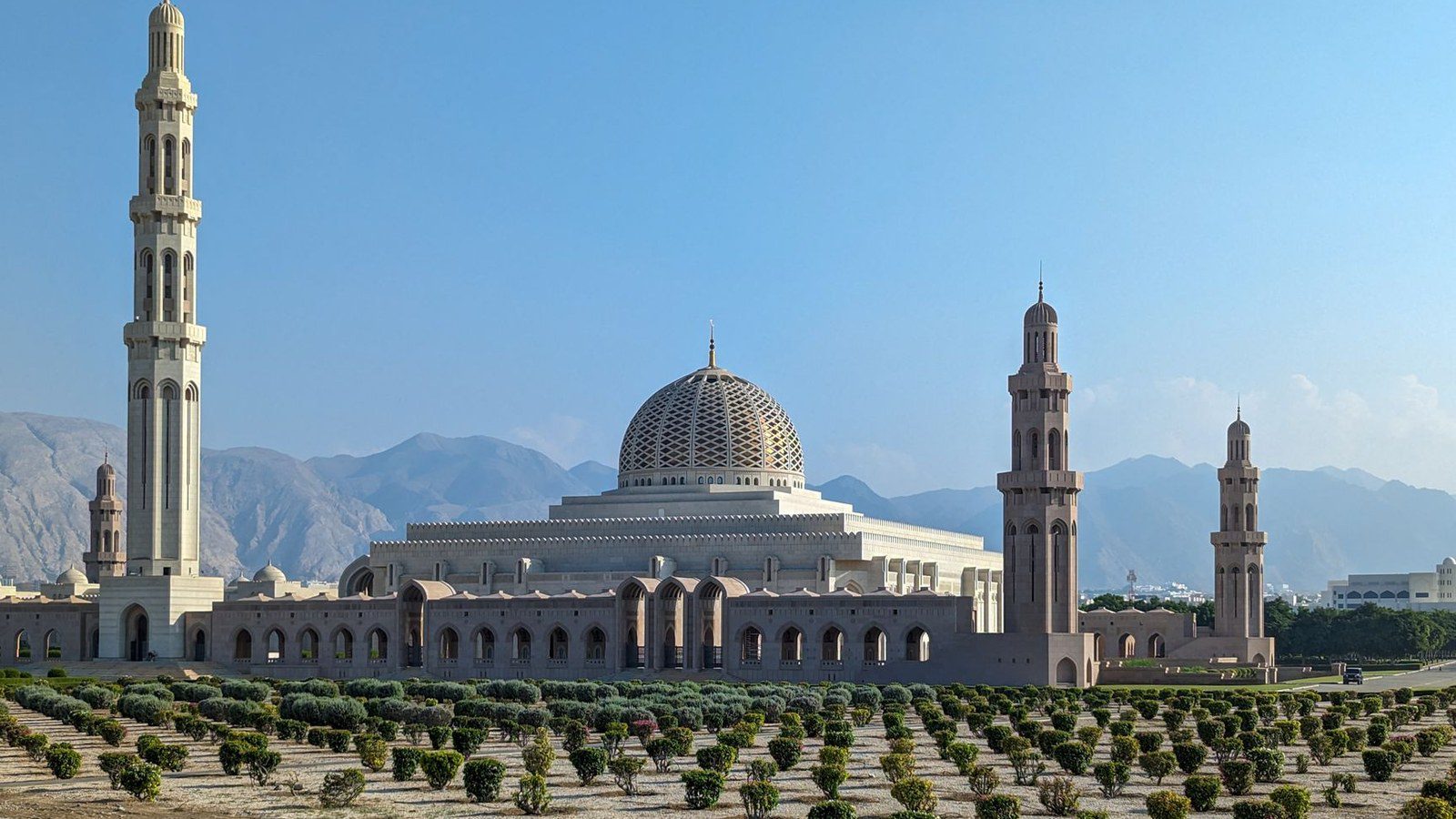 Sultan Qaboos Grand Mosque with its striking minarets against a clear blue sky in Muscat, Oman.