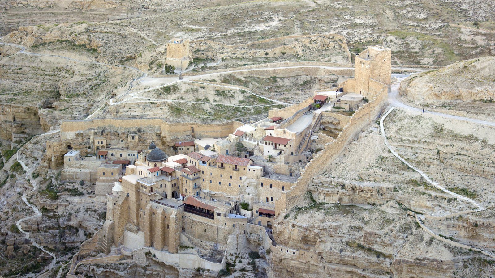 Dramatic aerial view of the ancient Mar Saba Monastery built into the sheer sandstone cliffs of the Kidron Valley in the West Bank