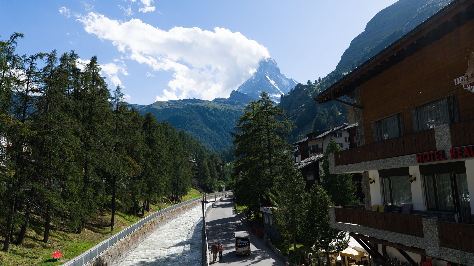 Scenic view of the Matterhorn from Zermatt with alpine architecture and flowing river.