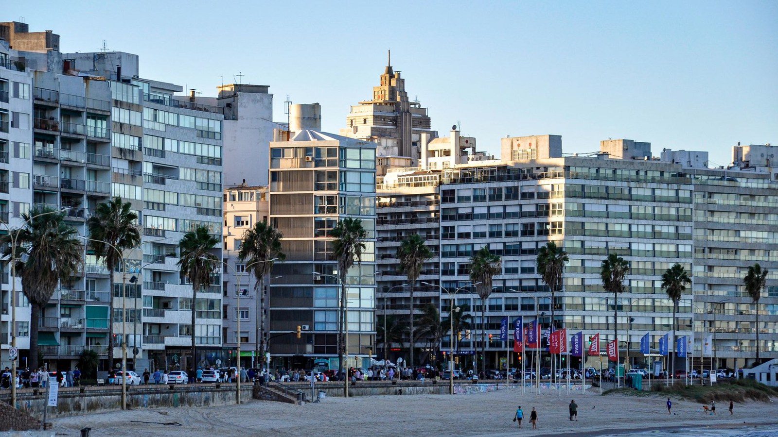 Wide curving sandy shoreline of Pocitos Beach framed by the scenic coastal promenade and modern skyline of Montevideo, Uruguay