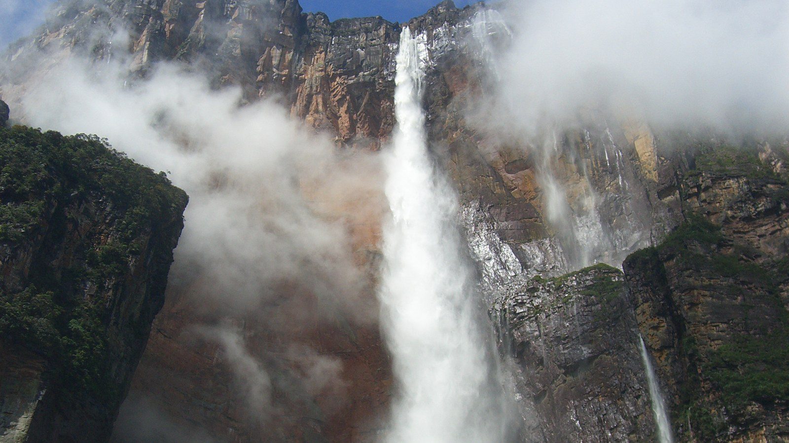 Towering dramatic drop of Angel Falls plunging from the summit plateau of Auyán-tepui into lush rainforest in Venezuela